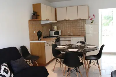 a kitchen with a table and chairs in a room at Paomia in Cargèse