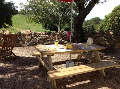 a picnic table with an umbrella and a bench at Paomia in Cargèse