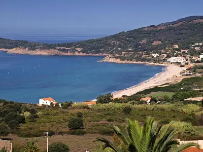 a view of a beach with houses and the ocean at Paomia in Cargèse