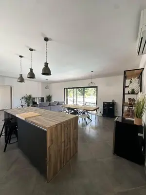 a living room with a kitchen and a table at VILLA BENOA in Oletta