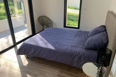 a bedroom with a bed with purple sheets and a window at VILLA BENOA in Oletta