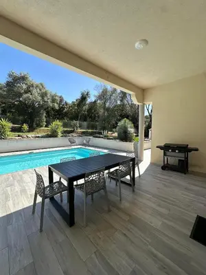 a patio with a table and chairs next to a pool at VILLA BENOA in Oletta