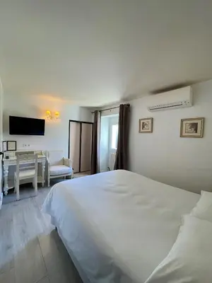 a bedroom with a large white bed and a desk at Franceschini in Ghisonaccia