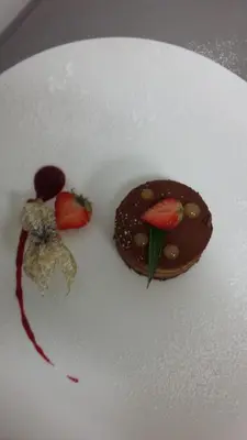 a plate with a chocolate dessert with strawberries on it at Franceschini in Ghisonaccia