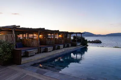 a resort with a swimming pool next to the water at Villa Kirssis in Porticcio