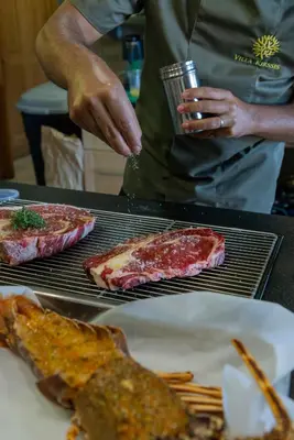 a man is preparing food on a grill at Villa Kirssis in Porticcio