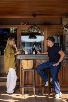 a man and a woman sitting at a bar at Villa Kirssis in Porticcio