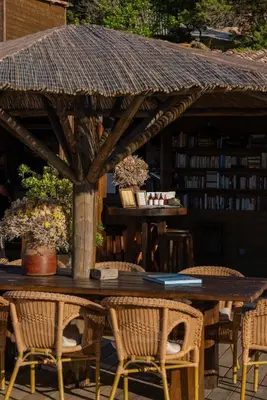a wooden table with chairs and a library with books at Villa Kirssis in Porticcio