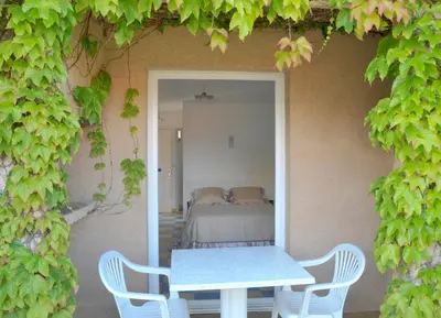 a table and chairs in a room with a bed at Résidence Colombara in Cargèse