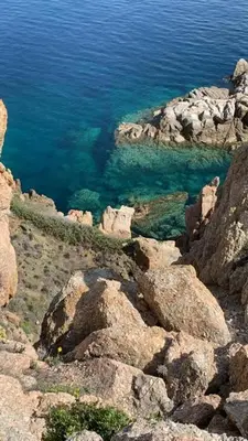 a view of the ocean from a mountain with rocks at Résidence Colombara in Cargèse