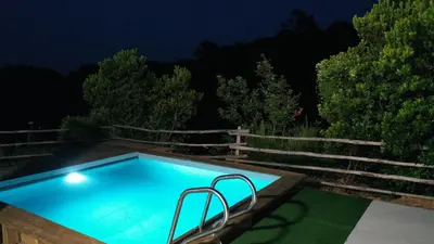 a swimming pool at night with a fence at Corse et Zen VILLA SUR LES BOIS 85m2 5à7 pers in Taglio-Isolaccio