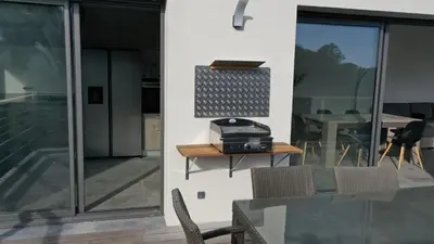 a living room with a table and chairs and a glass door at Corse et Zen VILLA SUR LES BOIS 85m2 5à7 pers in Taglio-Isolaccio