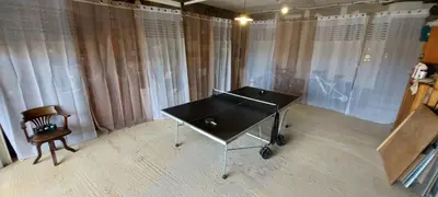 a table and a chair in a room with curtains at Corse et Zen VILLA SUR LES BOIS 85m2 5à7 pers in Taglio-Isolaccio
