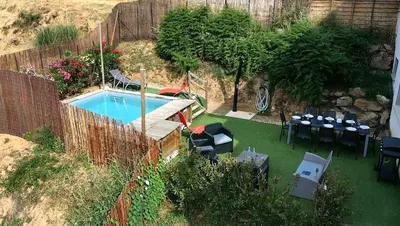 a backyard with a swimming pool and tables and chairs at Corse et Zen LOFT ZEN 145m2 8à9 pers in Taglio-Isolaccio