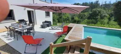 a patio with a table and an umbrella next to a pool at Corse et Zen LOFT ZEN 145m2 8à9 pers in Taglio-Isolaccio