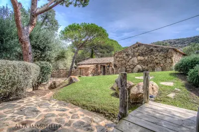 a wooden pathway leading to a stone house at Villa Serenita Pallombaggia in Porto-Vecchio