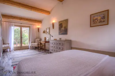 a bedroom with a bed and a table and a window at Villa Serenita Pallombaggia in Porto-Vecchio