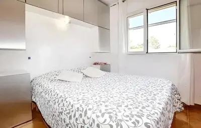 a bedroom with a bed with a black and white comforter at Villa ensoleillée & Piscine privée à Aléria in Aléria