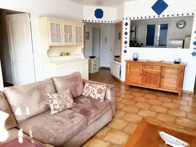 a living room with a couch and a kitchen at Villa ensoleillée & Piscine privée à Aléria in Aléria