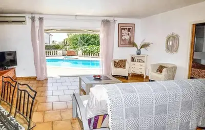 a living room with a bed and a pool at Villa ensoleillée & Piscine privée à Aléria in Aléria