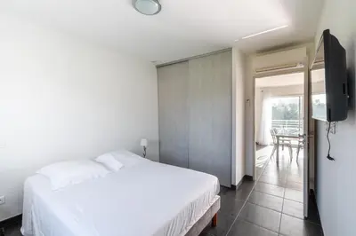 a bedroom with a white bed and a television at Matteo Laricio in Peri