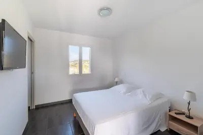 a white bedroom with a bed and a window at Matteo Laricio in Peri