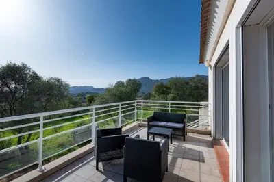 a balcony with chairs and a view of the mountains at Matteo Laricio in Peri