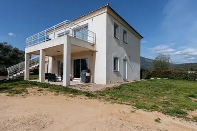 a white house with a balcony on top of a field at Matteo Leccia in Peri