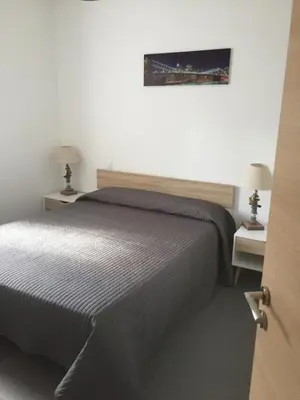 a bedroom with a bed and two tables and two lamps at VILLAS MATTEU in Galeria