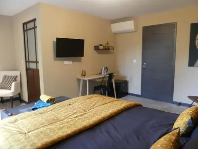 a bedroom with a bed with a television and a desk at Casa Peppina - Chez Tonio et Sylvie in Sari Solenzara