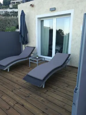 a balcony with two chairs on a wooden deck at Casa Peppina - Chez Tonio et Sylvie in Sari Solenzara