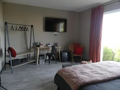 a bedroom with a bed and a desk and a tv on the wall at Casa Peppina - Chez Tonio et Sylvie in Sari Solenzara