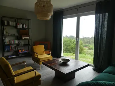 a living room with a table and chairs and a large window at Casa Peppina - Chez Tonio et Sylvie in Sari Solenzara