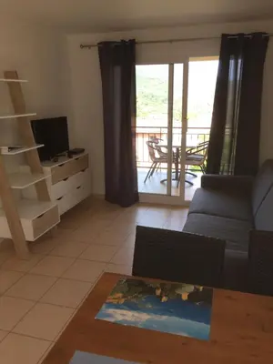 a living room with a couch and a television at Appart'Hôtel A Punta in Galeria