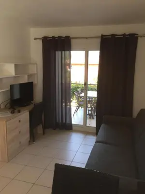 a living room with a couch and a television at Appart'Hôtel A Punta in Galeria