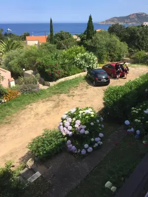 a car parked in a driveway with flowers at Appart'Hôtel A Punta in Galeria