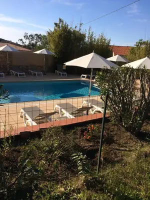 a swimming pool with lounge chairs and umbrellas at Appart'Hôtel A Punta in Galeria