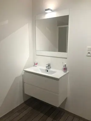 a white bathroom with a sink and a mirror at Joli T2 récent 'Le VIVALDI' in Ajaccio