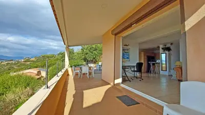 a balcony of a house with a view of the ocean at Soleil Topaze - 68 m2 - Terrasse - Jardinet - Transats - Vue mer panoramique sur toute la baie in Porticcio