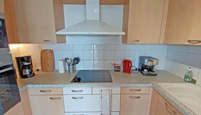 a kitchen with a sink and a stove top oven at Soleil Topaze - 68 m2 - Terrasse - Jardinet - Transats - Vue mer panoramique sur toute la baie in Porticcio