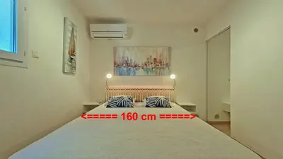a bedroom with a large bed in a room at Soleil Topaze - 68 m2 - Terrasse - Jardinet - Transats - Vue mer panoramique sur toute la baie in Porticcio