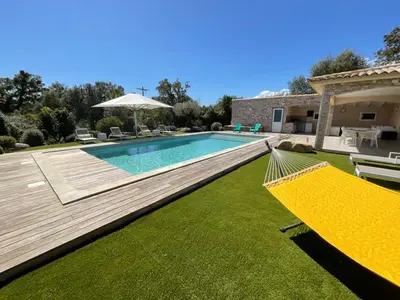 a swimming pool with a hammock in a yard at Villa Poggio Rosso - Pool-House & Piscine chauffée in Sainte-Lucie de Porto-Vecchio