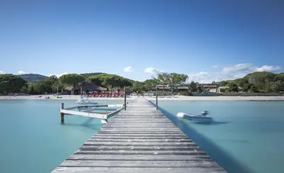 a wooden dock with two boats on the water at Villa Poggio Rosso - Pool-House & Piscine chauffée in Sainte-Lucie de Porto-Vecchio