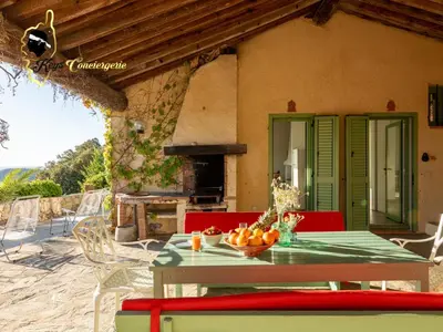a table with a bowl of fruit on it in front of a house at Villa Acciagina 10 pers PISCINE VUE MER PINARELLO Climatisée in Pinarellu