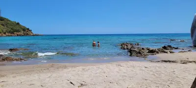 two people standing in the water at the beach at Villa Acciagina 10 pers PISCINE VUE MER PINARELLO Climatisée in Pinarellu