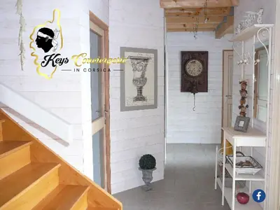 a staircase in a house with a clock on the wall at Dormir à Porto Vecchio (Trinité) in Porto-Vecchio