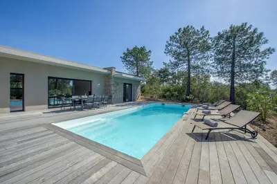 a swimming pool with lounge chairs and a house at Maison Del Onda in Lecci
