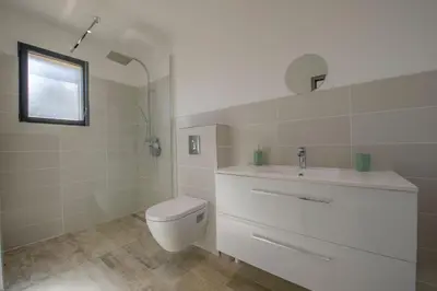 a white bathroom with a toilet and a sink at Maison Del Onda in Lecci