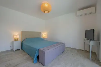 a bedroom with a bed and a couch and a tv at Maison Del Onda in Lecci