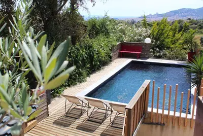 a pool with two chairs and a bench on a deck at Rez de villa bordure Ajaccio in Ajaccio